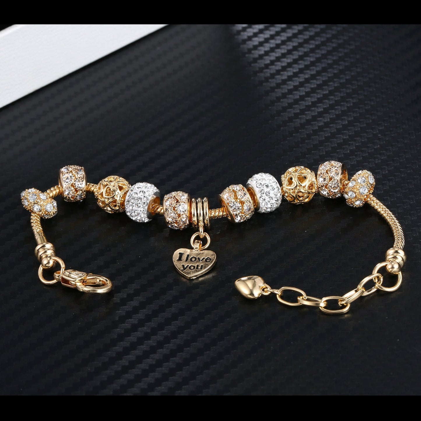 Gold plated bead bracelet with alternating crystal and amber-toned charms and heart pendant