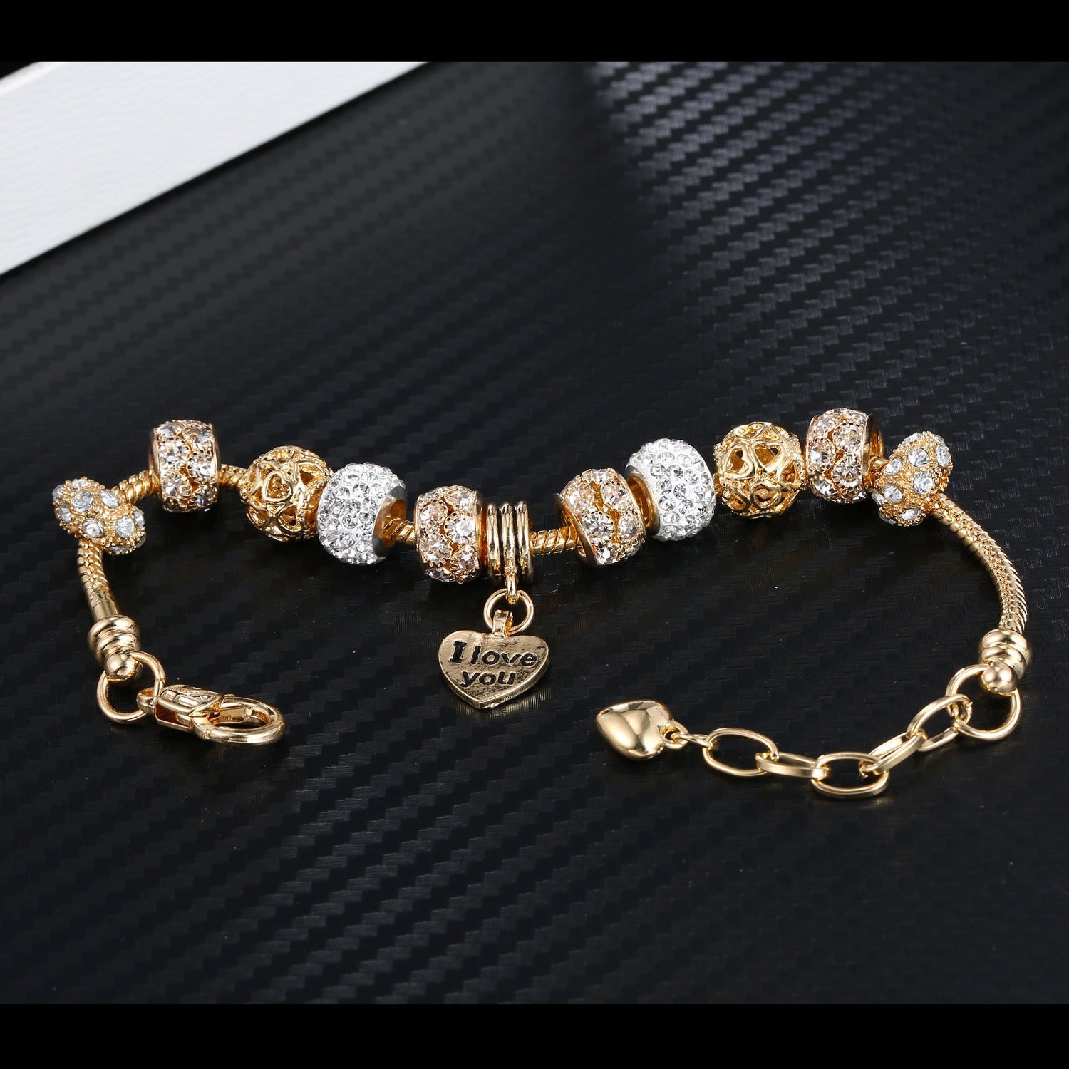 Gold plated bead bracelet with alternating crystal and amber-toned charms and heart pendant