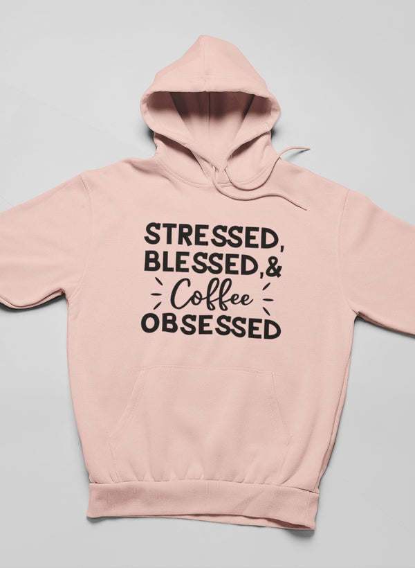 Light mauve hoodie with hood, front pouch pocket, and “Stressed Blessed & Coffee Obsessed” graphic