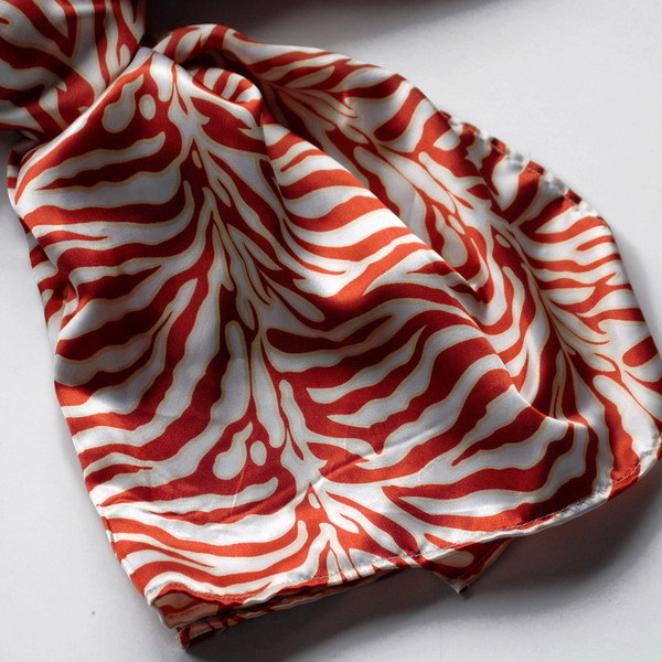 Close-up of red and white zebra-striped silk scarf with soft folds