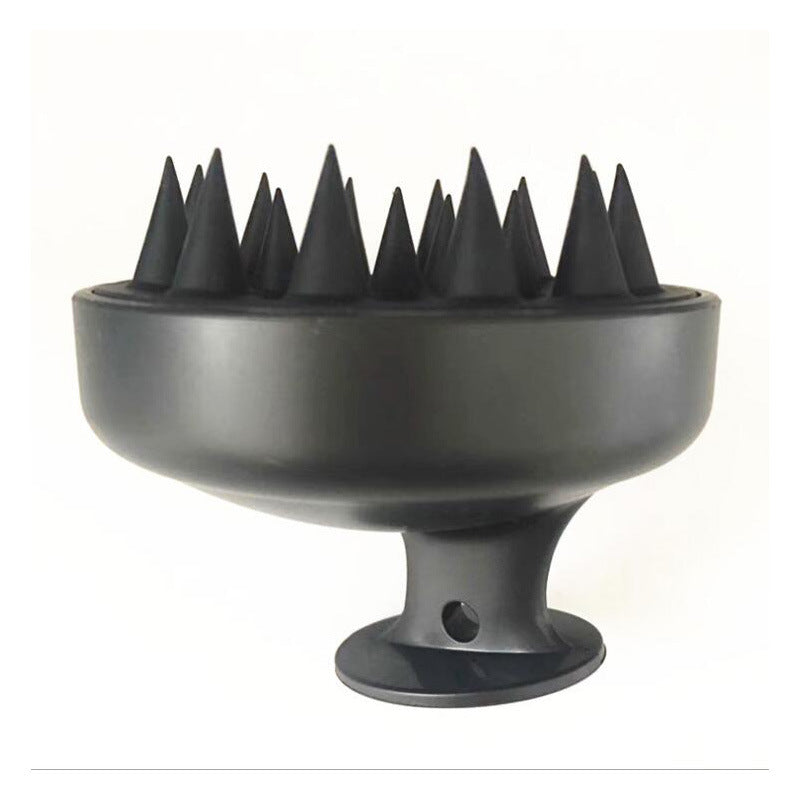Black silicone scalp massage brush with pointed spikes and suction base