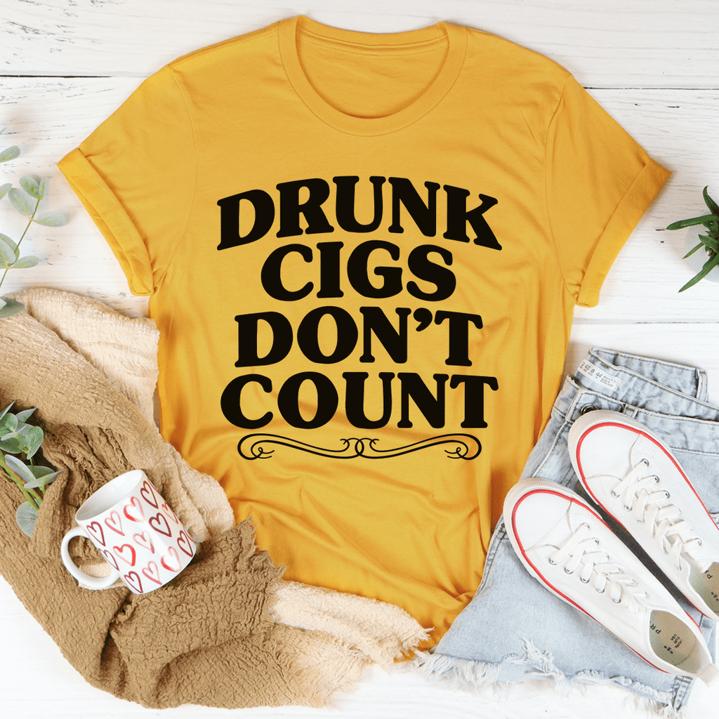Mustard yellow crew-neck T-shirt featuring 'DRUNK CIGS DON'T COUNT' text and swirls.