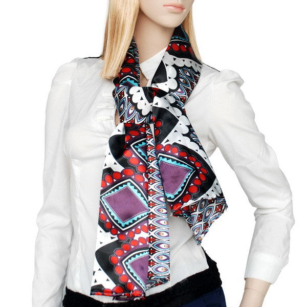 Silky scarf worn as neck wrap, black base with red, white, turquoise, and purple motifs