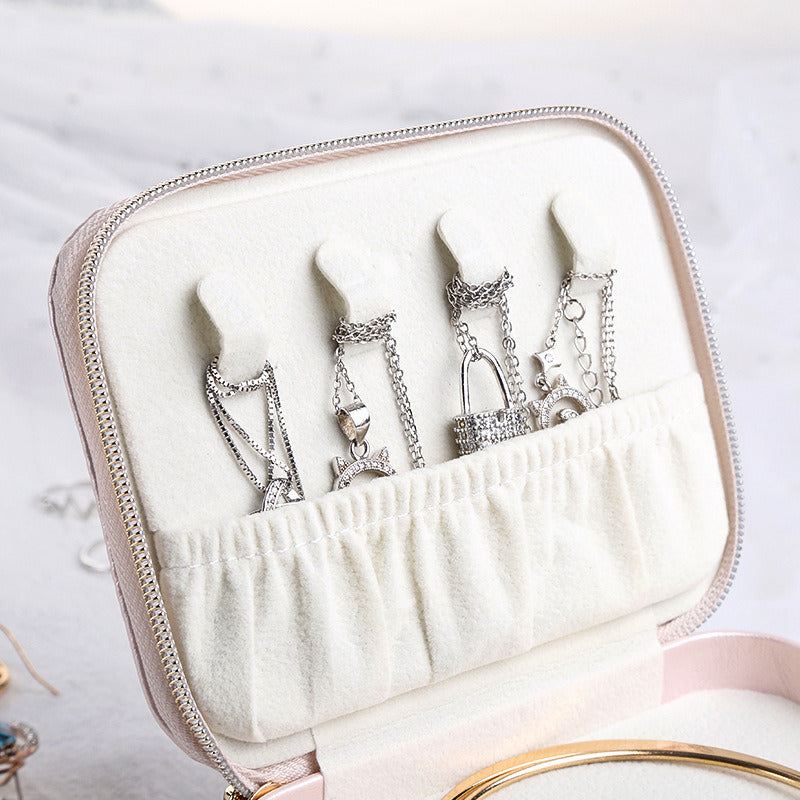 Pink jewelry case interior with ring and earring hooks in a fabric-lined holder
