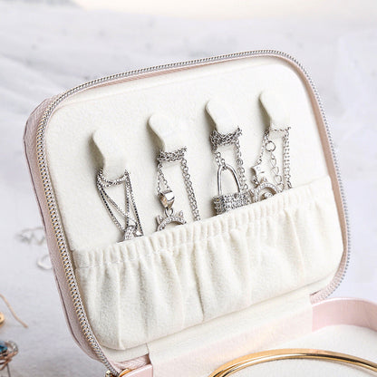 Pink jewelry case interior with ring and earring hooks in a fabric-lined holder