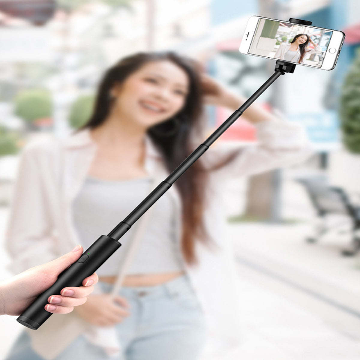 Black mini selfie stick held up with smartphone mounted
