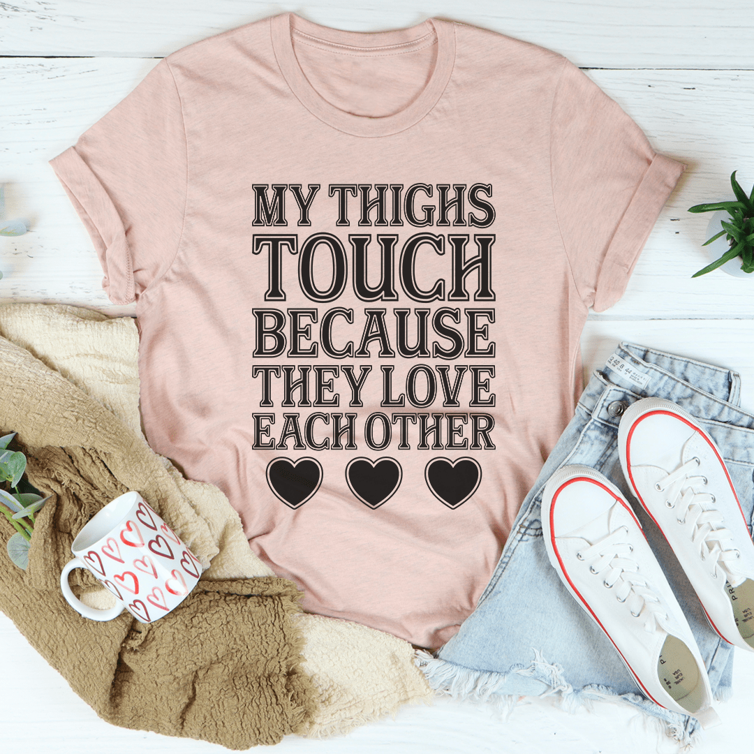 Light pink T-shirt with 'MY THIGHS TOUCH BECAUSE' text and heart icons