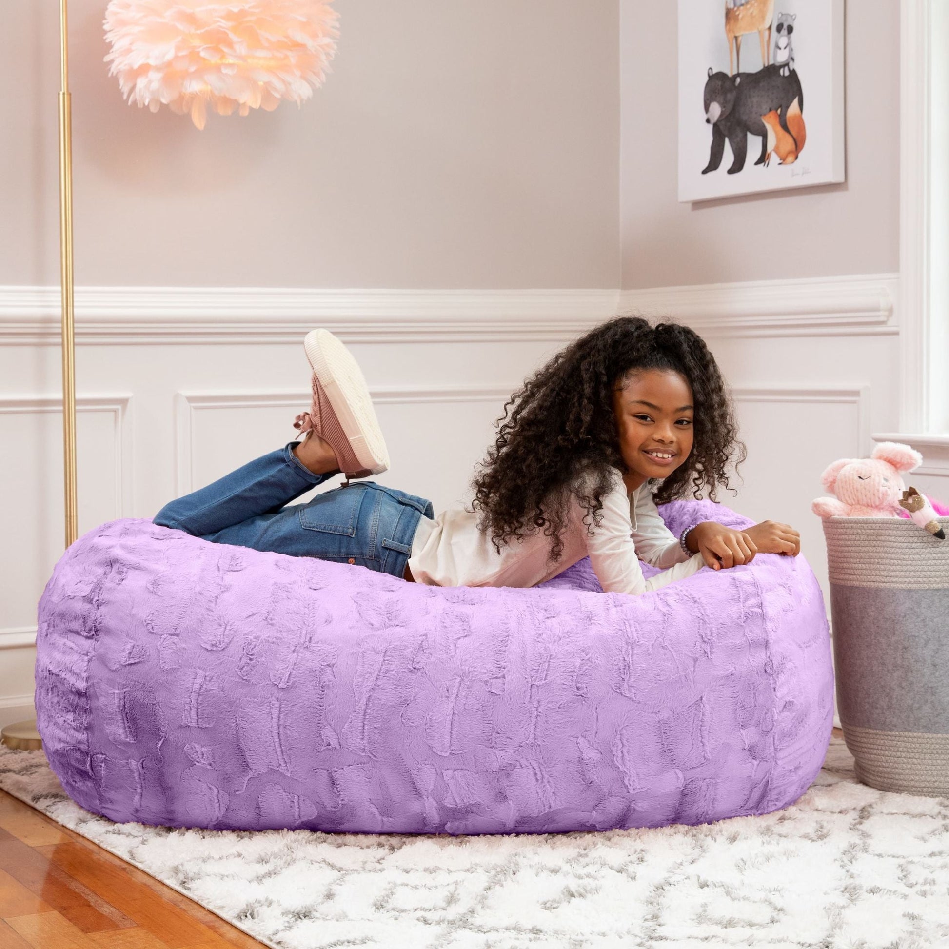 Purple faux fur 4-foot bean bag couch; child sits inside with toys nearby
