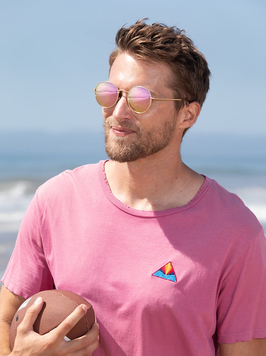 Side view of round polarized sunglasses with rose-tinted lenses and gold-tone metal frame