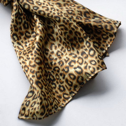 Leopard print silk scarf folded, detailed animal pattern in brown and black
