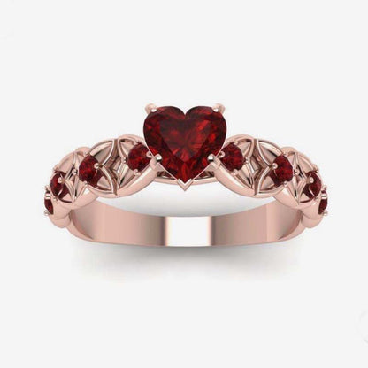 Heart zircon ring with dark red heart-shaped stone on rose-gold band with side stones