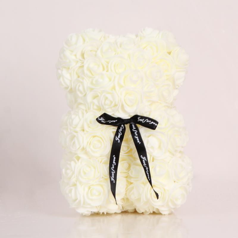 White rose teddy bear with black bow ribbon tied at the neck