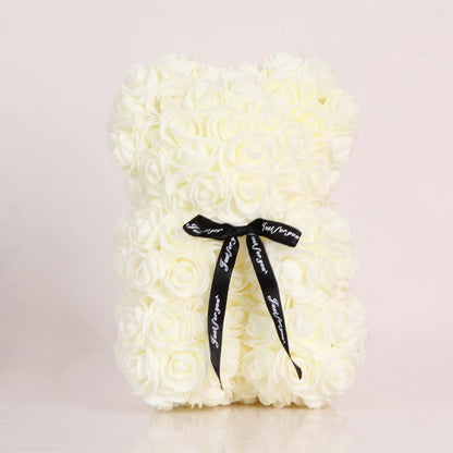 White rose teddy bear with black bow ribbon tied at the neck