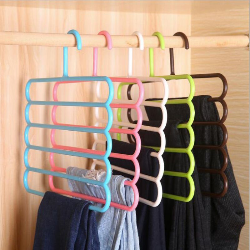 Multicolor 5-layer plastic hanger organizer on a rod with towels and folded clothes.