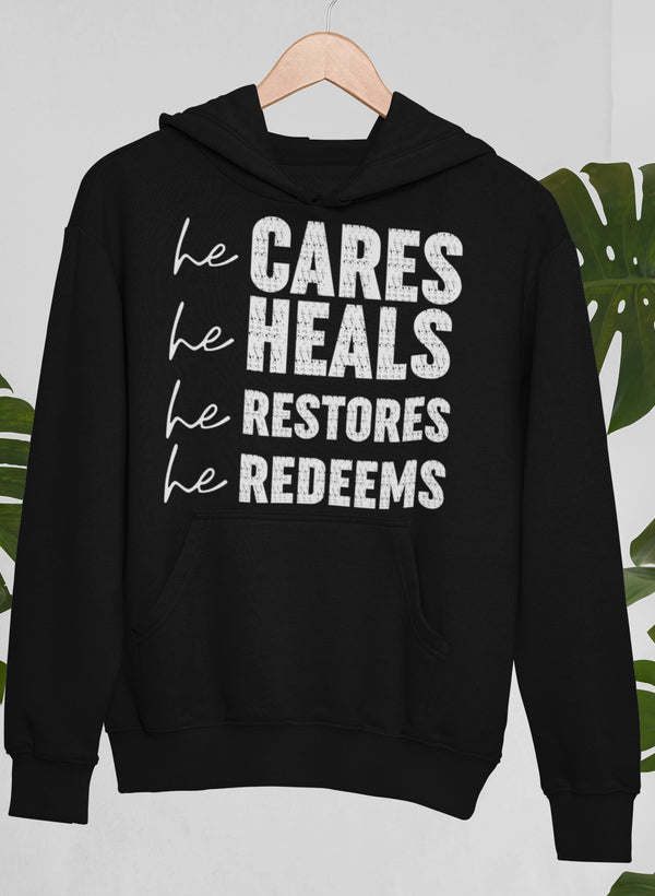 Black hoodie with pocket and 'he CARES he HEALS he RESTORES he REDEEMS'
