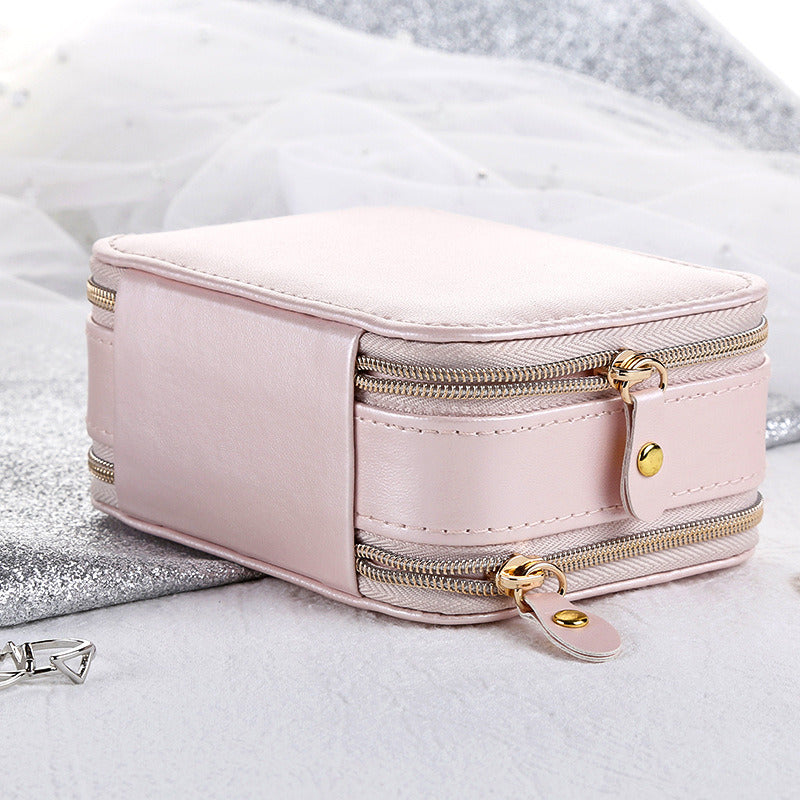 Pink jewelry organizer case with double zippers and gold-tone zipper pulls