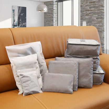 Gray packing cubes and organizers folded in a travel luggage storage set