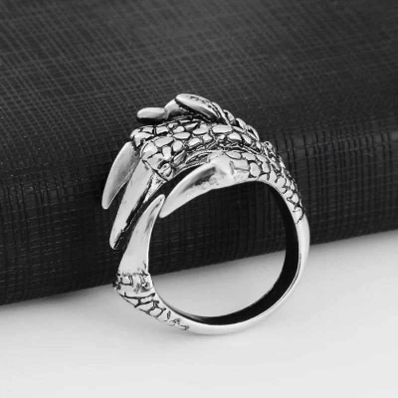 Silver open claw ring with dragon-scale texture and claw tips, curved band