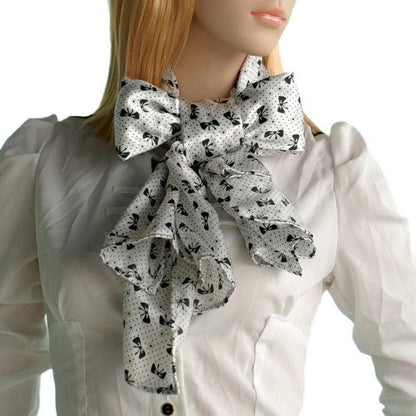 White silk scarf with black bow print, large tied bow at the neck