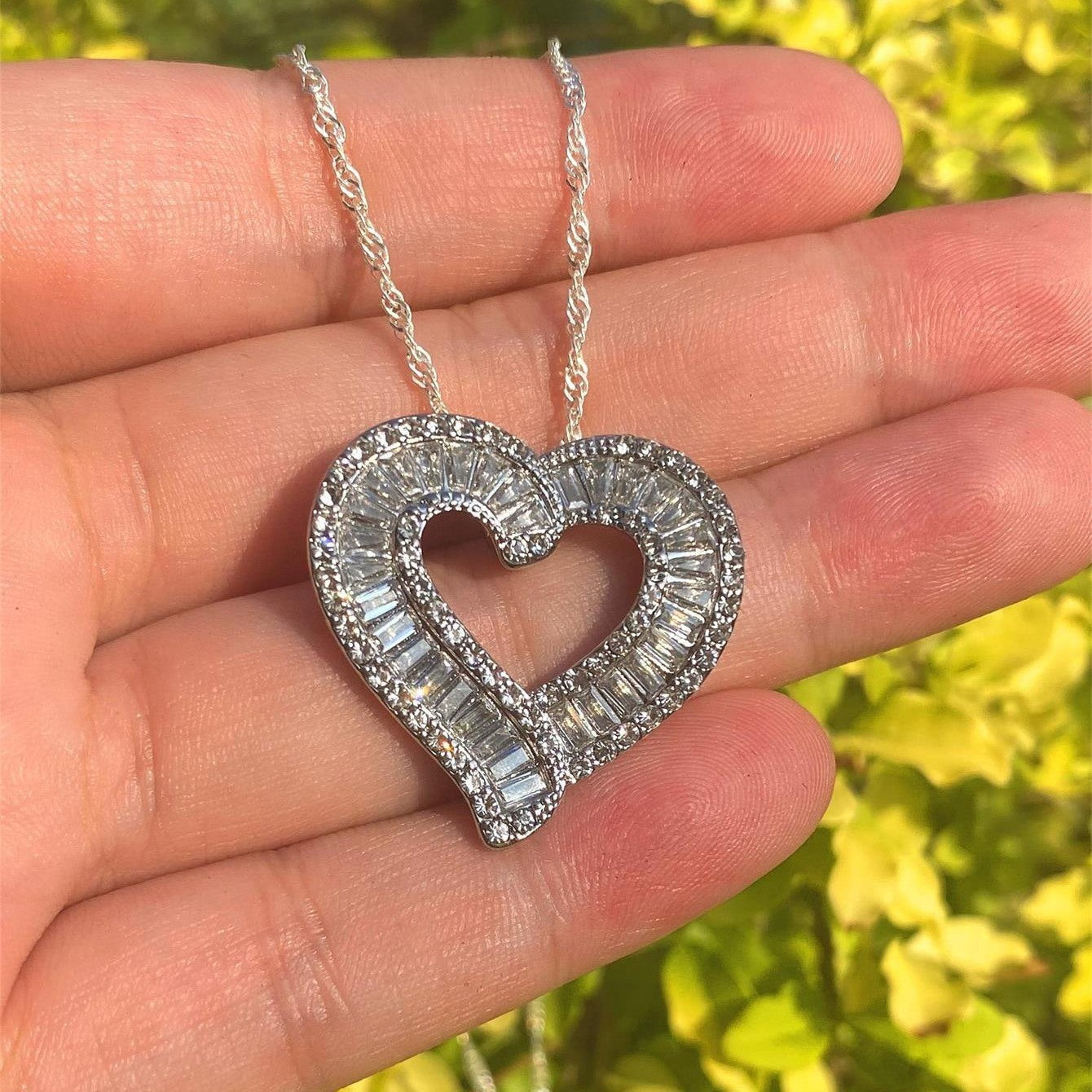 Heart pendant necklace with silver-tone heart and faux diamond rhinestones, side angle