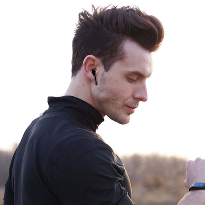Black wireless Bluetooth earbuds worn by man, side profile view