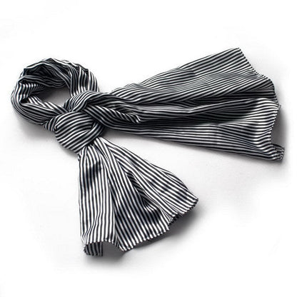 Black and white striped silk scarf wrap with fringed ends, folded and draped