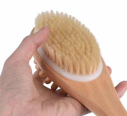 Close-up of wooden bath massage brush with tan bristles and rounded head