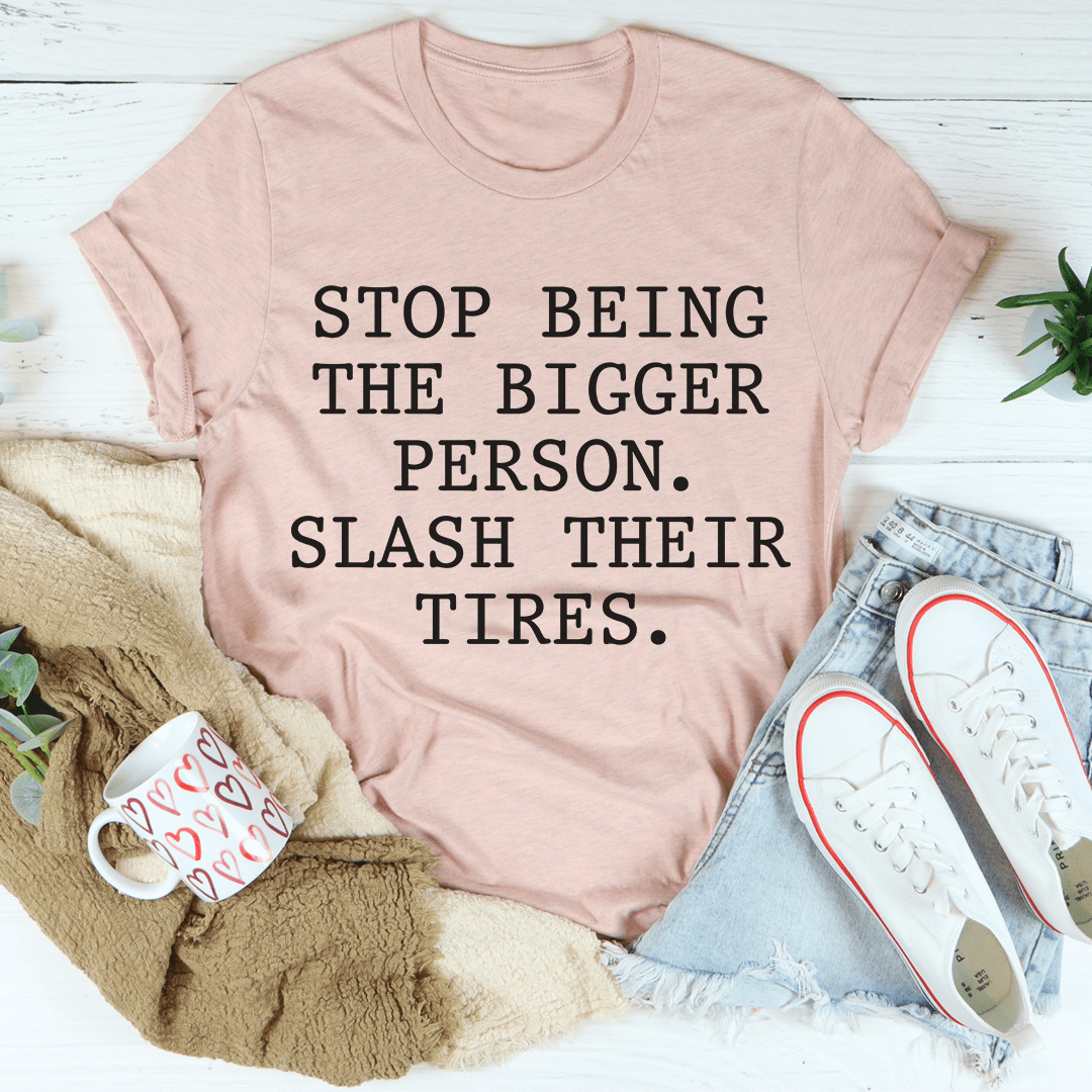 Mauve crewneck tee with black slogan: STOP BEING THE BIGGER PERSON. SLASH THEIR TIRES.
