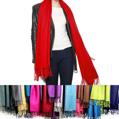 Red pashmina shawl with long fringe ends, worn as a wrap