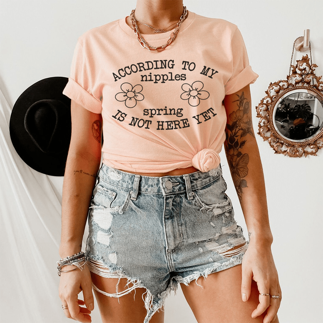 Peach crew-neck T-shirt with black slogan and flower graphic, worn with denim shorts