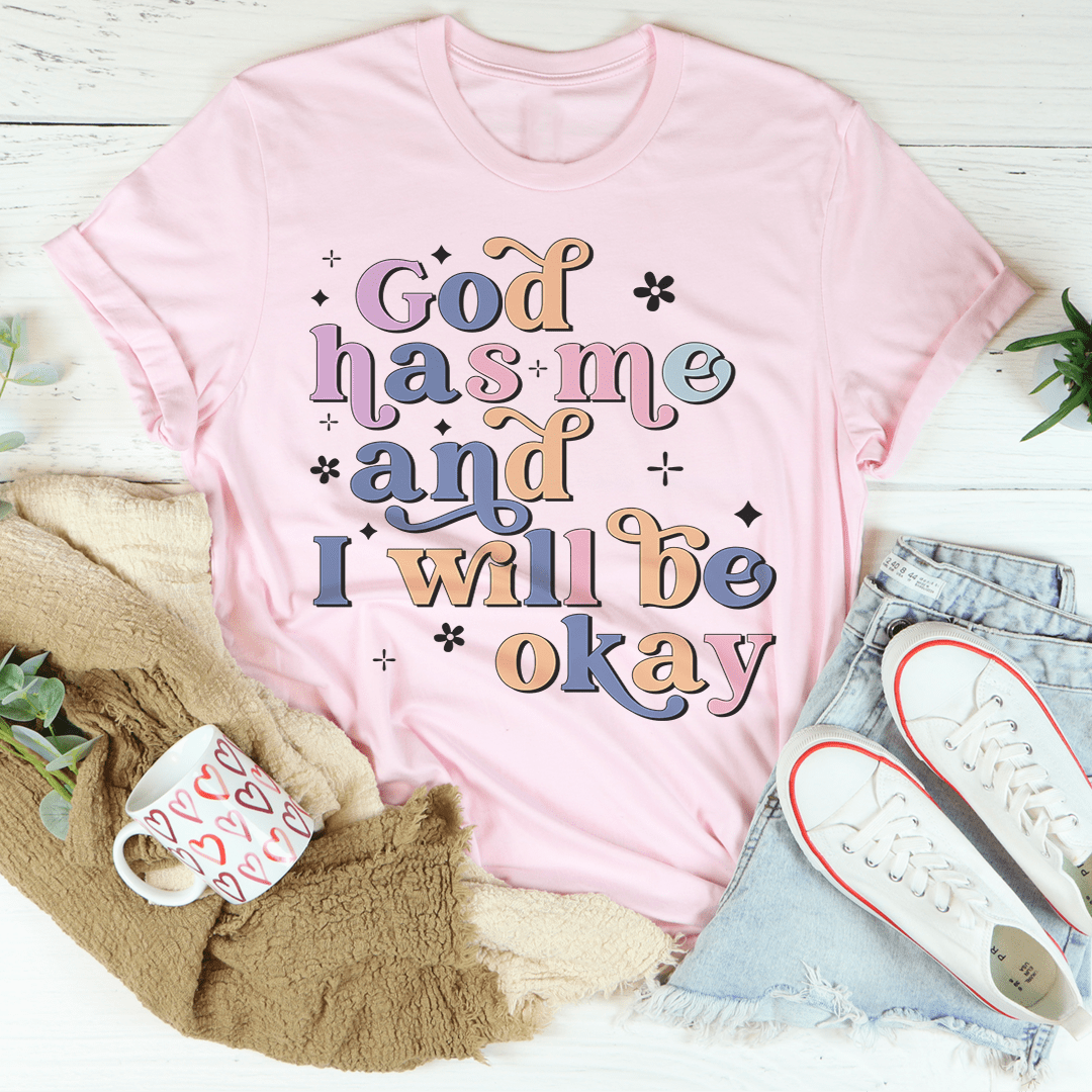 Pink crew-neck T-shirt with 'God has me and I will be okay' text graphic