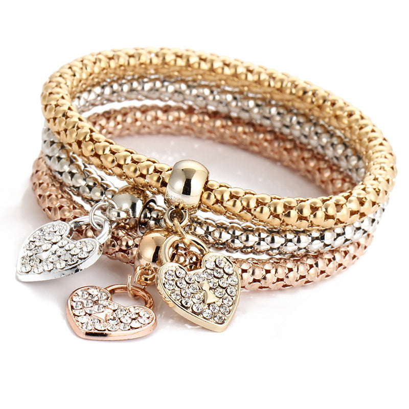 Multicolor rhinestone bracelet with dangling heart charms and three tone chain rows