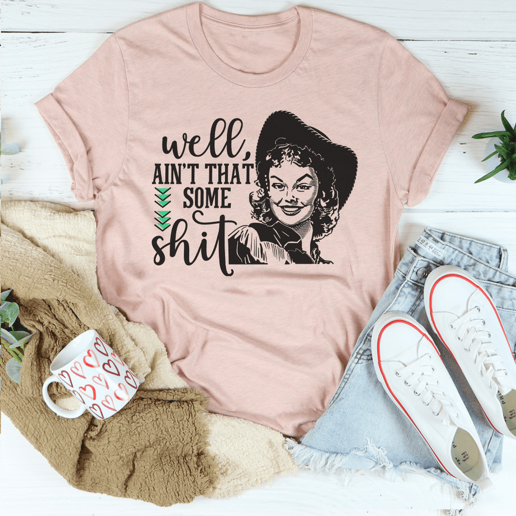 Mauve graphic T-shirt with illustrated face and stacked “Ain’t that some shit” text
