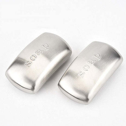 Pair of stainless steel odor remover bars, curved rectangular shapes with embossed text