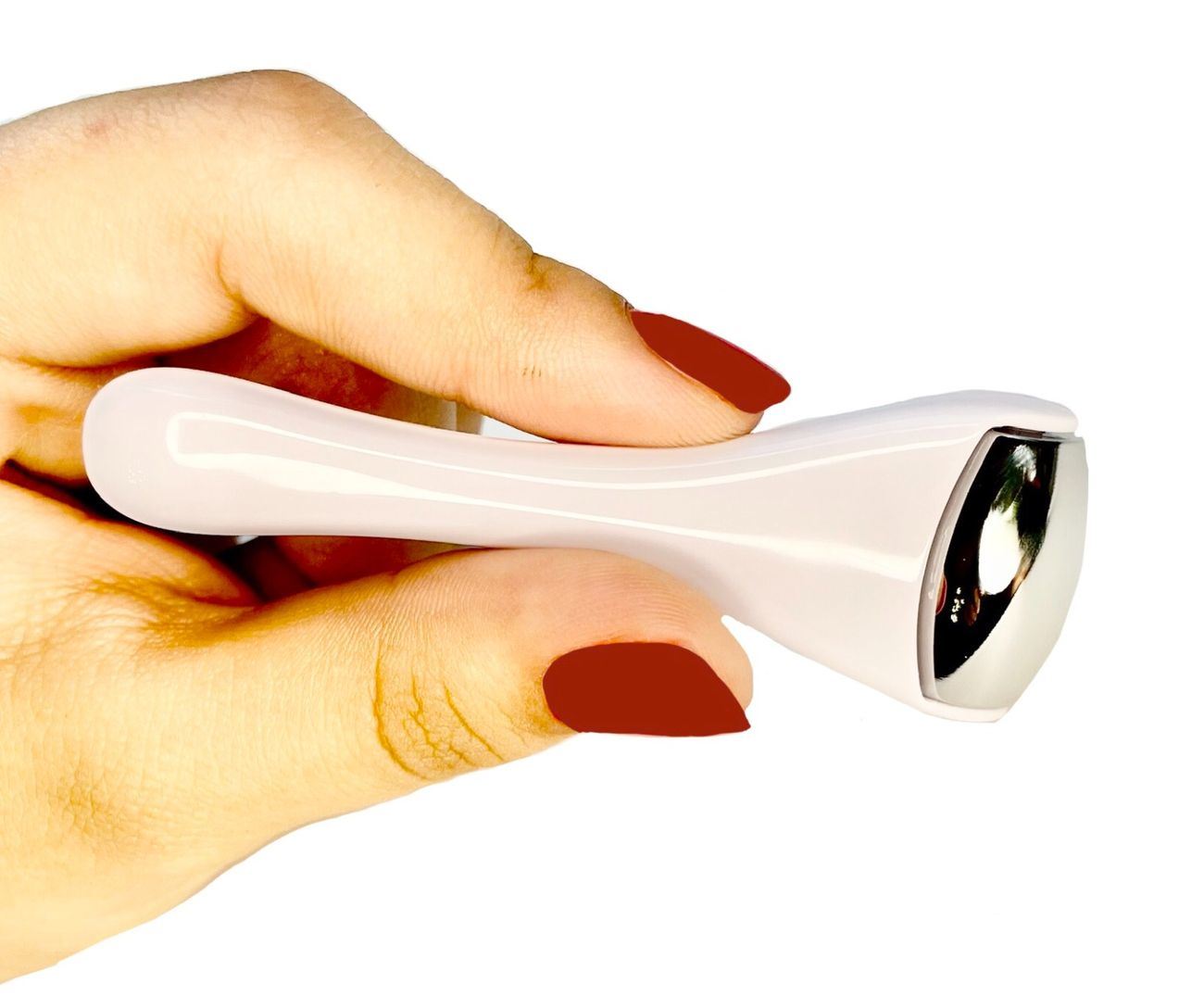 Ice roller massager with white handle and silver end, held by fingers