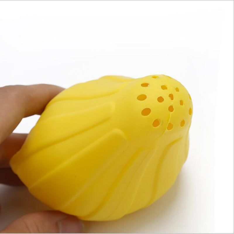 Yellow silicone citrus juicer press held in hand, perforated juice face