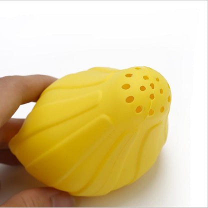 Yellow silicone citrus juicer press held in hand, perforated juice face