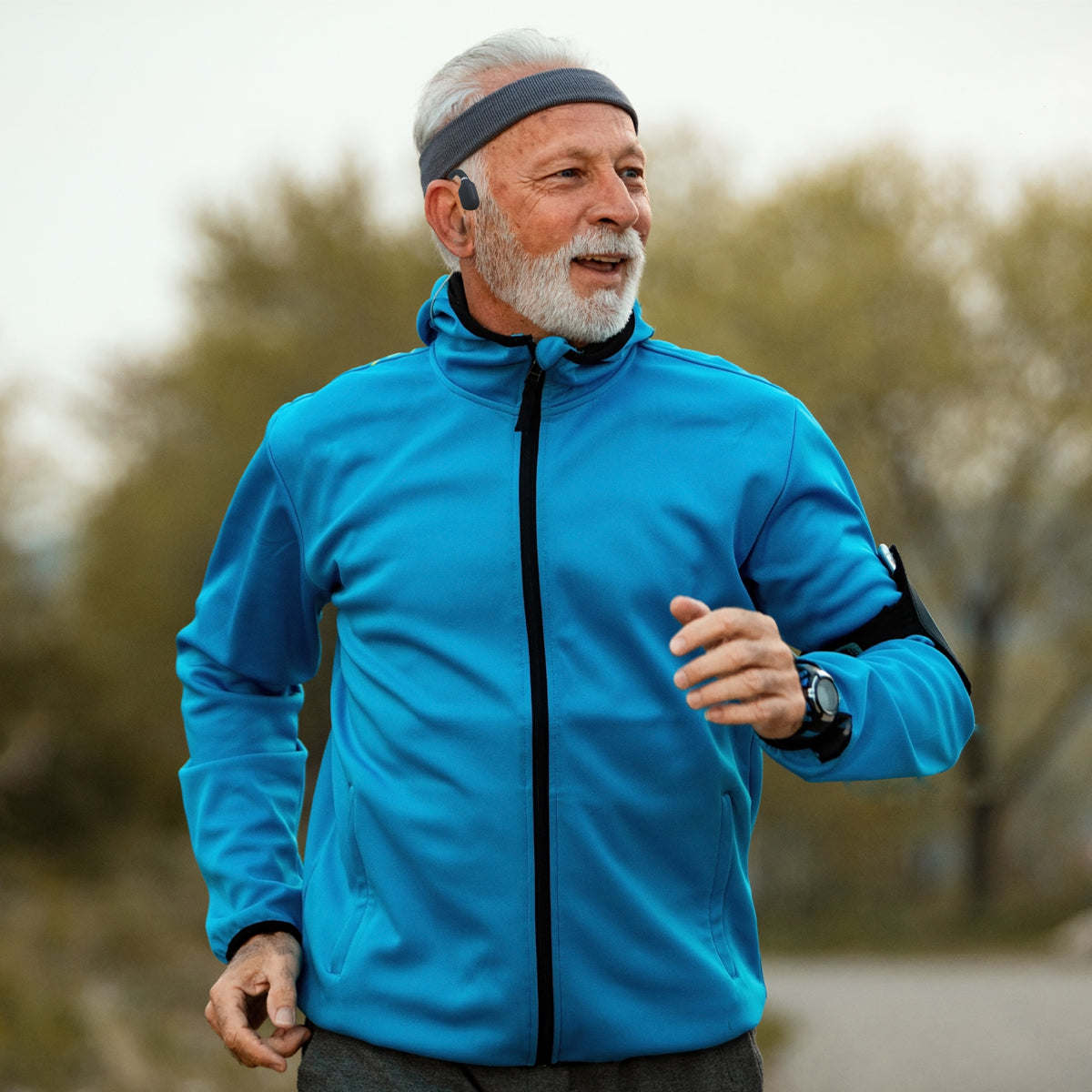 Open-ear wireless headphones worn by runner, visible earhook microphone