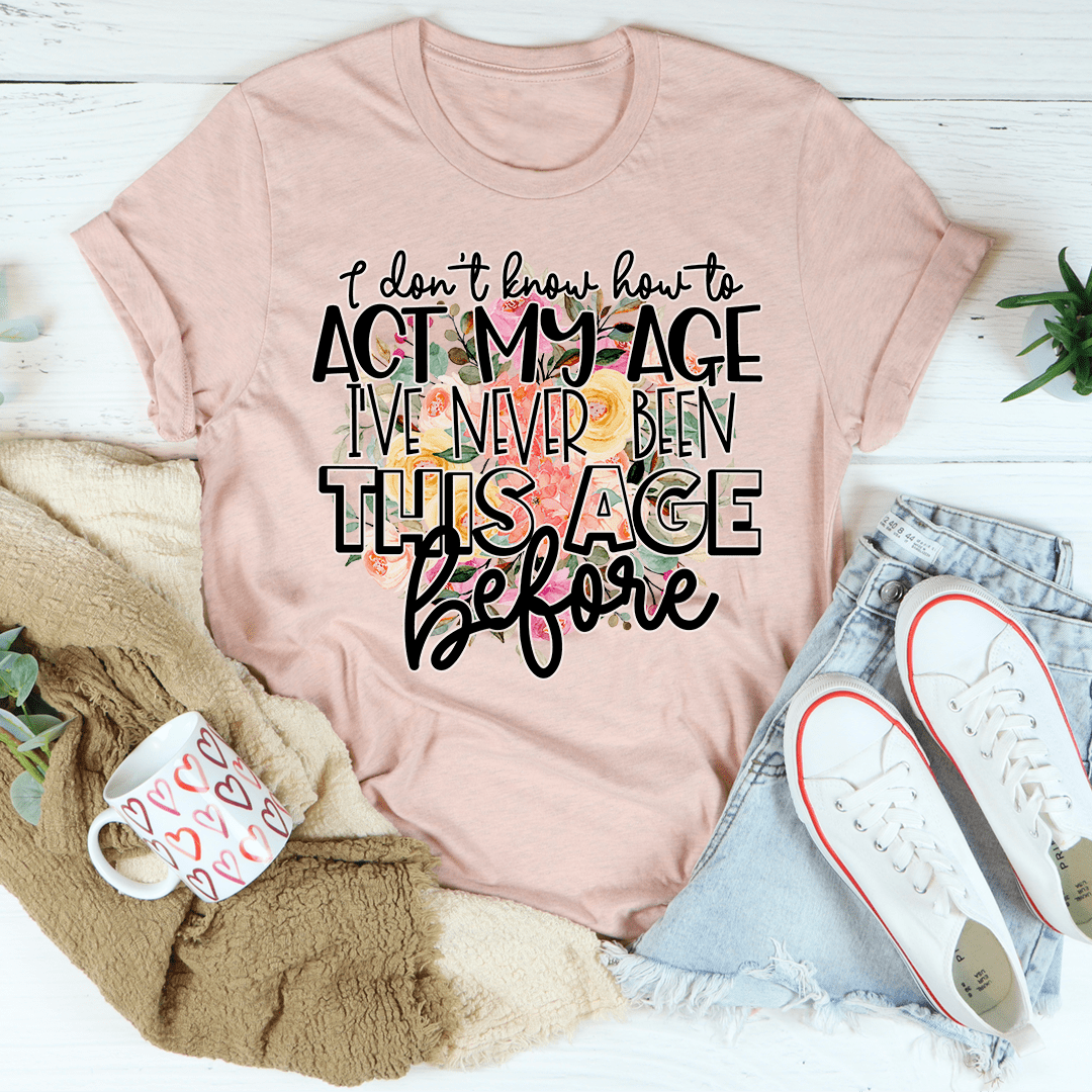 Blush crewneck graphic T-shirt with 'act my age' slogan in bold script