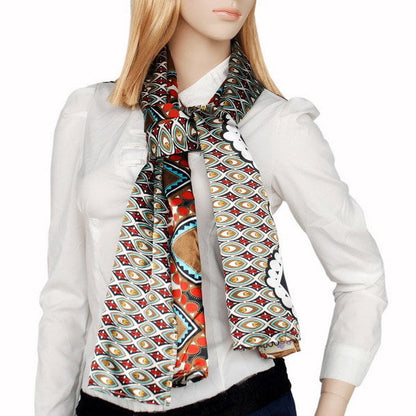 Patterned scarf worn around neck; brown, black, red and teal with medallion border