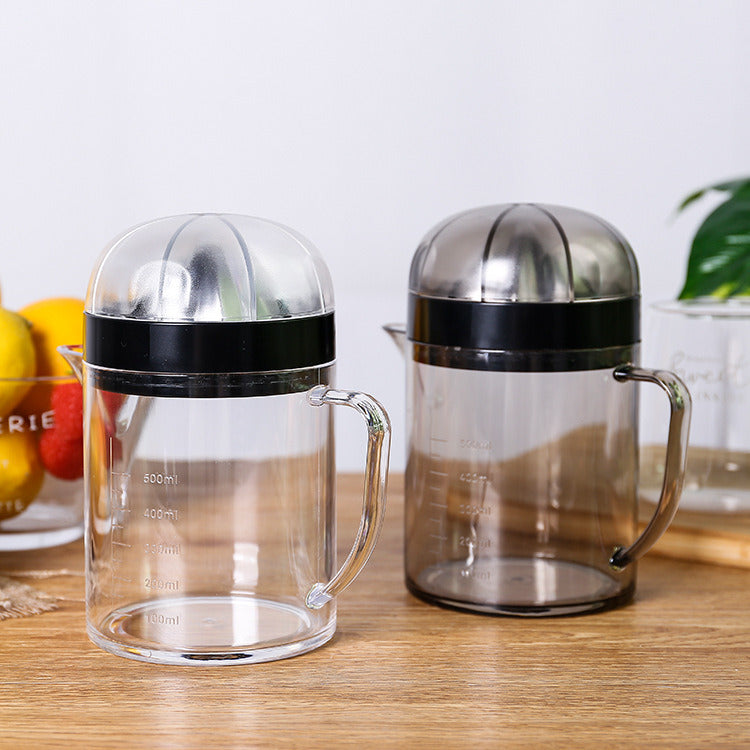 Pair of clear citrus juicer pitchers with black base collars and stainless reamer domes