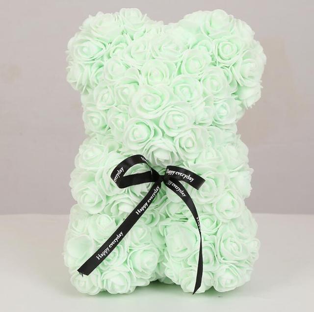 Light mint rose teddy bear with layered petals and black bow ribbon
