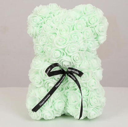 Light mint rose teddy bear with layered petals and black bow ribbon