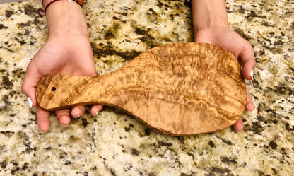 Olive-wood cutting board with oval handle, rustic grain and knot detail