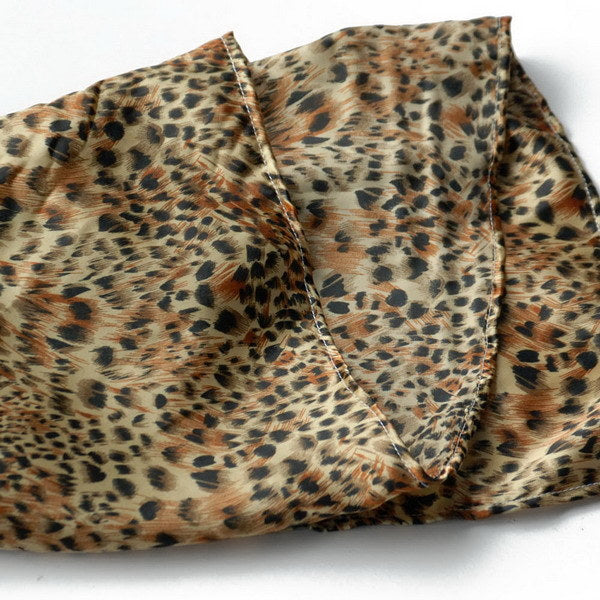 Leopard print scarf fabric closeup with stitched seam and frayed edge