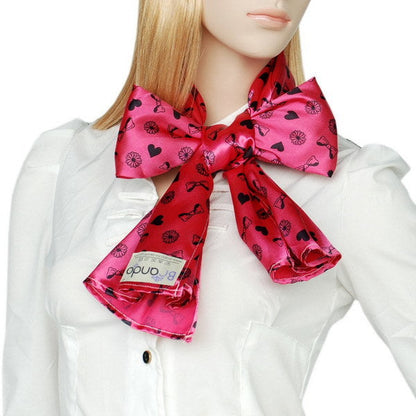 Pink silk scarf bow-tie with heart-and-flower print, worn over shirt collar