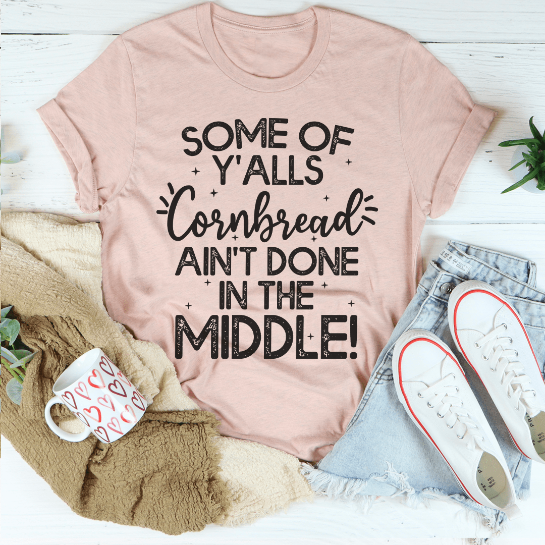 Dusty pink T-shirt with cornbread slogan graphic: 'Ain't Done In The Middle'
