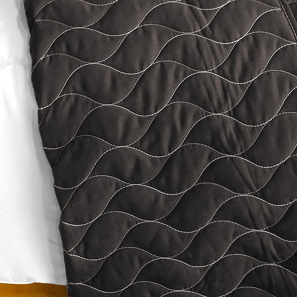Black quilt panel with wavy vermicelli stitching in silver thread