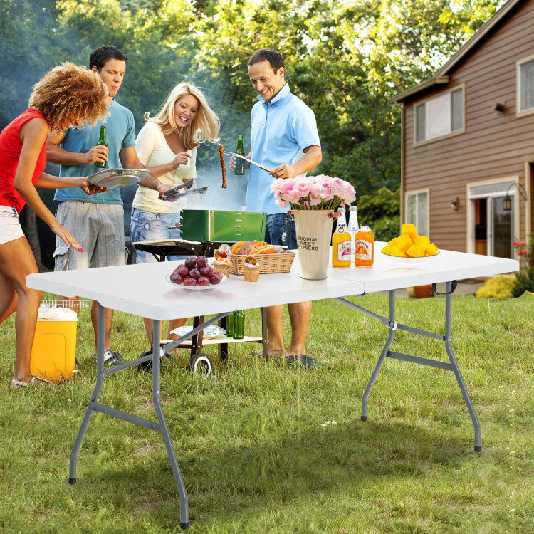 White portable folding camping table with gray metal legs outdoors
