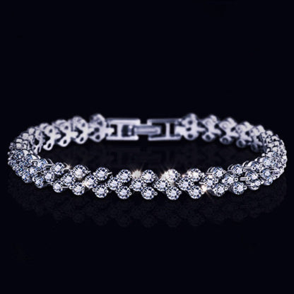 Silver tennis bracelet with round stones, hinged clasp, and link details